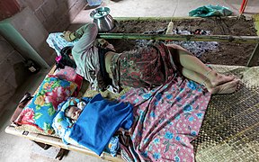 Mother and newborn sleeping on a bamboo bed near a campfire in a house in Don Det Laos.jpg